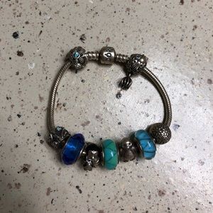 Pandora bracelet with 7 charms and 2 clips.
